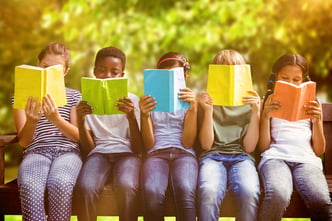 Children reading books at park against trees and meadow in the park-1