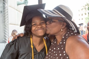 PA Virtual graduate of color receiving a kiss on cheek from her mother