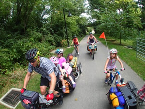 group of adults and children biking on path