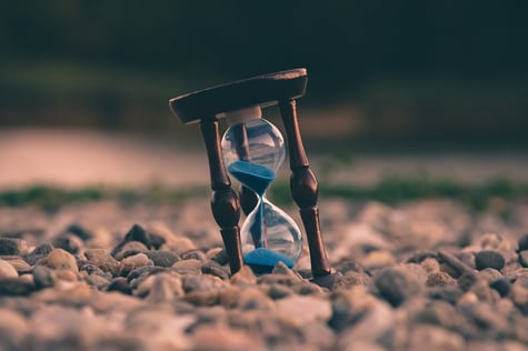 sand timer sitting on rocks