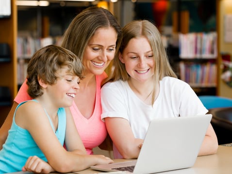 Mother with kids in library with notebook-1