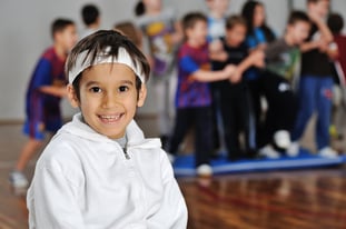 Portrait of sporty kid playing group games at gym hall