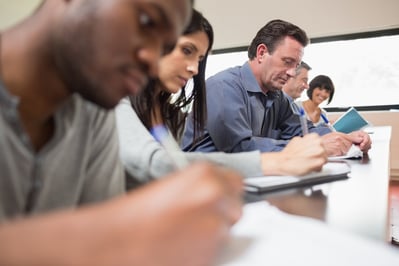 Students in a lecture with one woman looking up in college