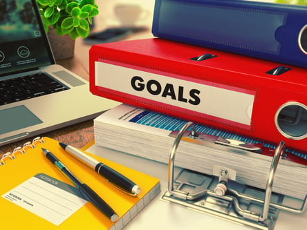 Red Office Folder with Inscription Goals on Office Desktop with Office Supplies and Modern Laptop. Business Concept on Blurred Background. Toned Image.